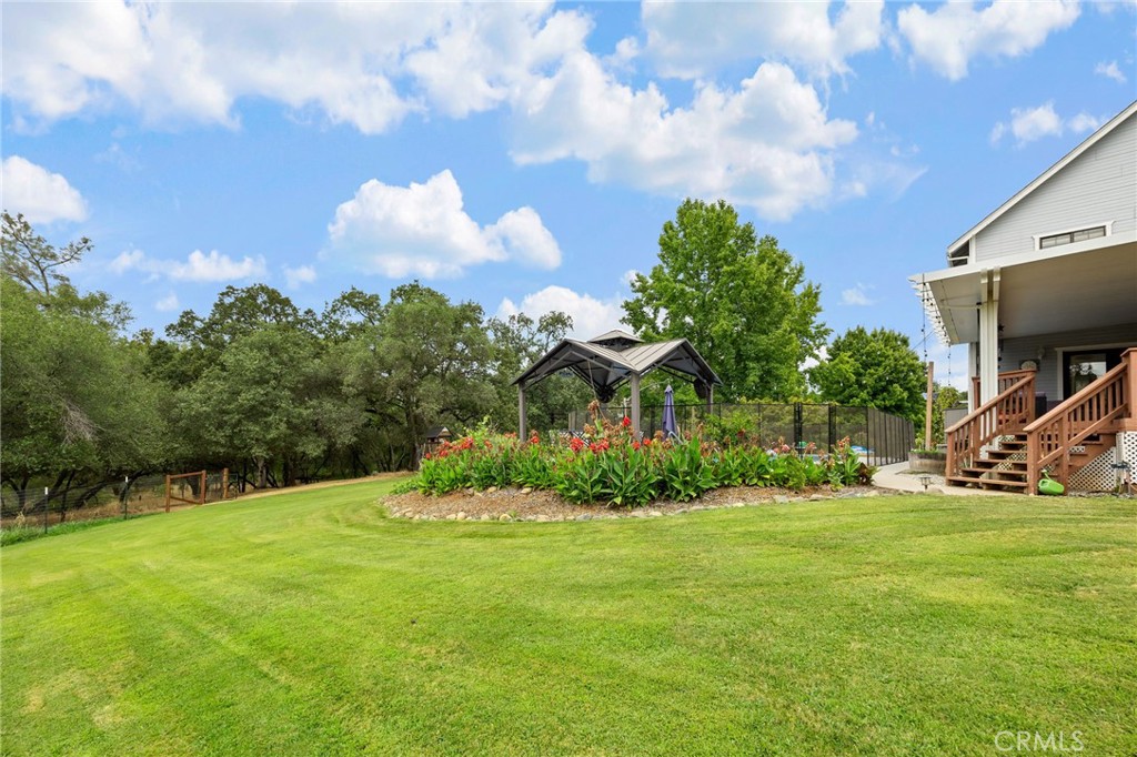 83 Gopher Road Oroville, CA 95966 - Photo 61 of 69 a big yard with swimming pool and trees in the background