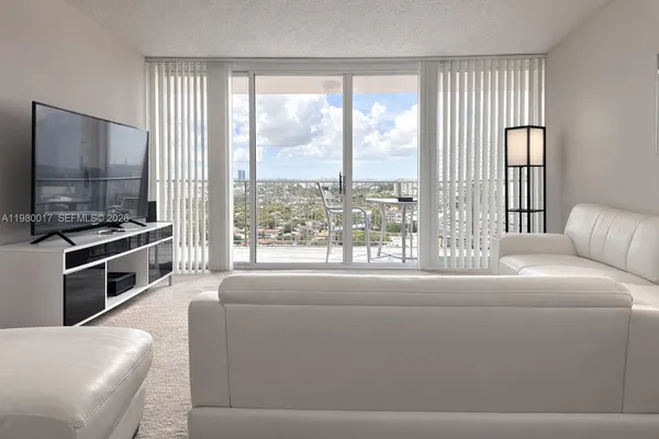 a living room with furniture and a floor to ceiling window