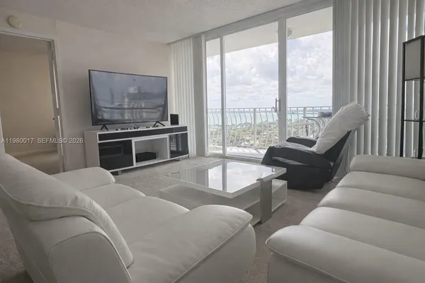 a living room with furniture and a floor to ceiling window
