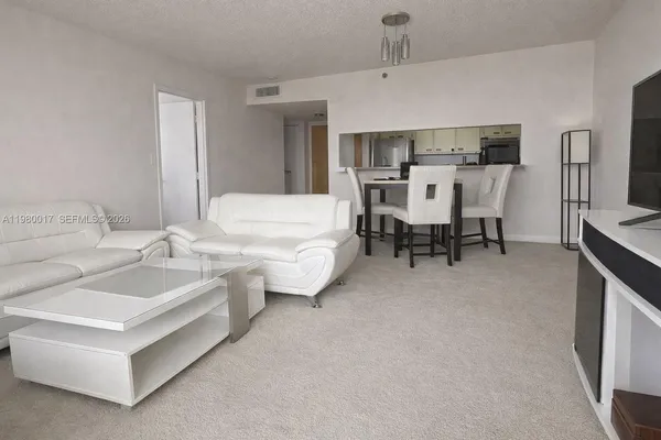 a living room with furniture and kitchen view