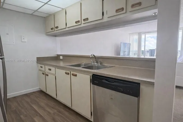 a kitchen with stainless steel appliances granite countertop a sink and dishwasher with wooden cabinets