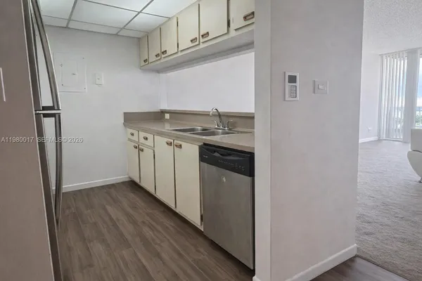 a kitchen with stainless steel appliances granite countertop a sink and a refrigerator