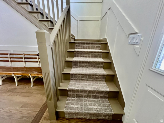 812 East Bates Cyn Road Tooele, UT 84074 - Photo 52 of 144 Staircase featuring a patterned carpet runner, painted balusters and newel post, and wainscoting paneling