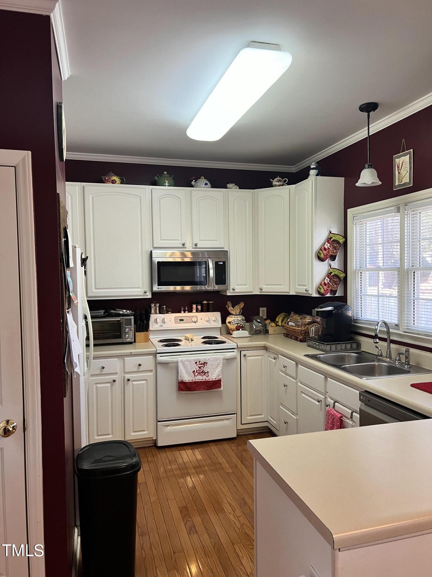 7709 Harps Mill Woods Run Raleigh, NC 27615 - Photo 6 of 15 a kitchen with a sink a stove a refrigerator and cabinets
