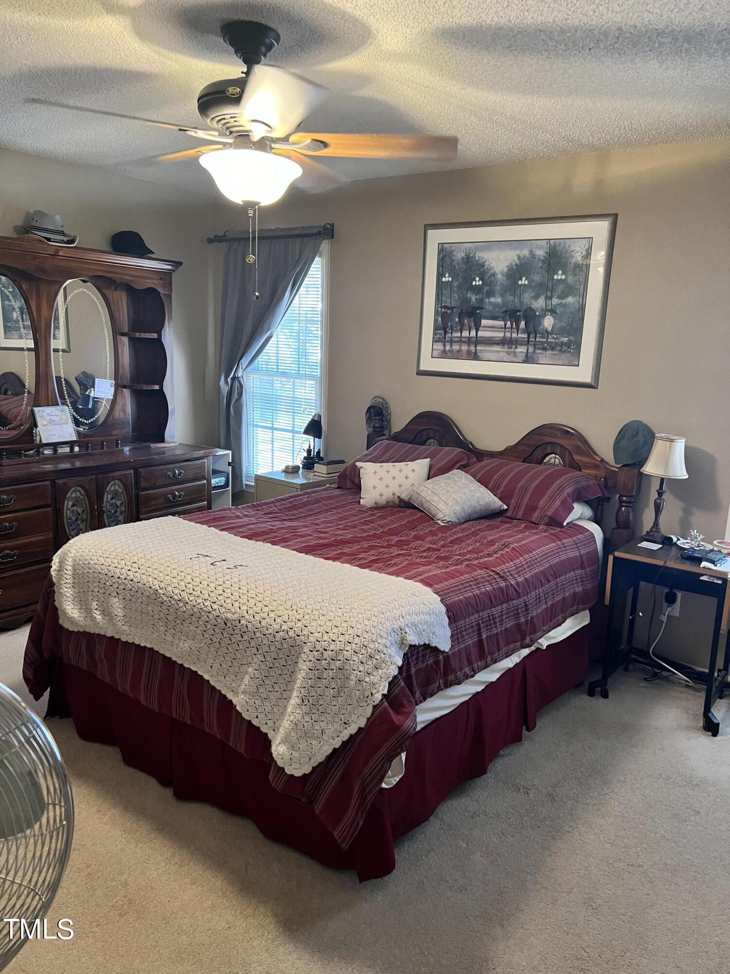 7709 Harps Mill Woods Run Raleigh, NC 27615 - Photo 8 of 15 a bedroom with a bed painting on wall and a large mirror
