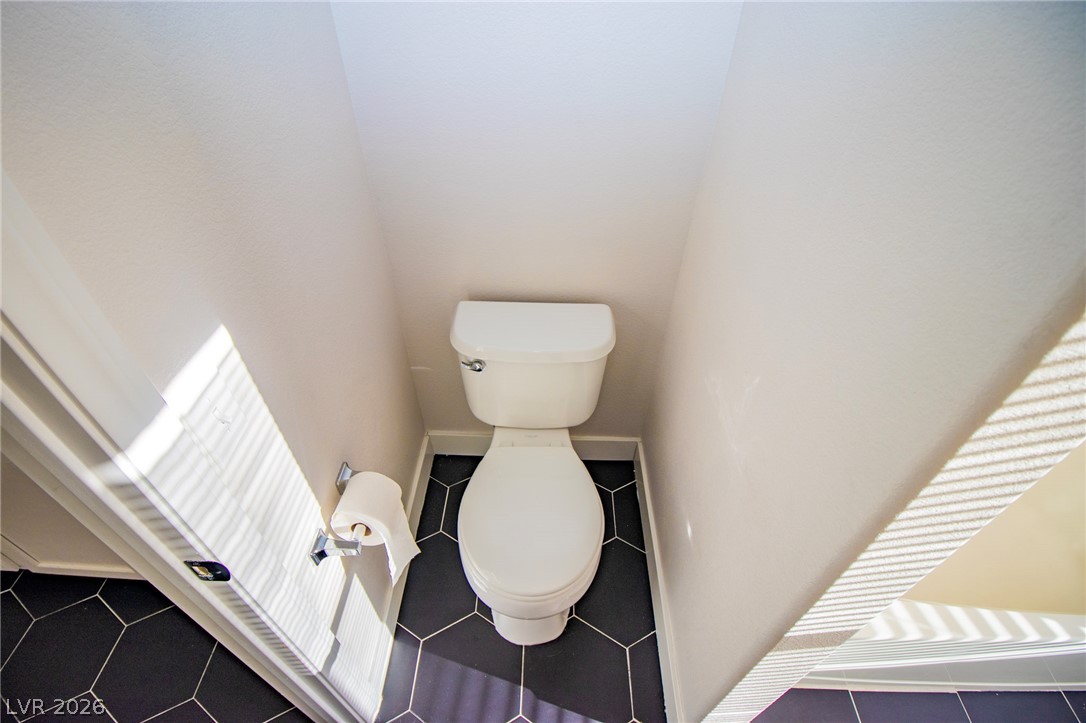 1468 Reef Ridge Court Las Vegas, NV 89128 - Photo 15 of 22 A private toilet alcove features striking hexagon tile flooring, offering a unique design touch.