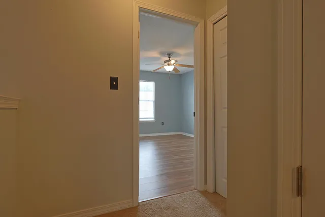 a view of a hallway with wooden floor