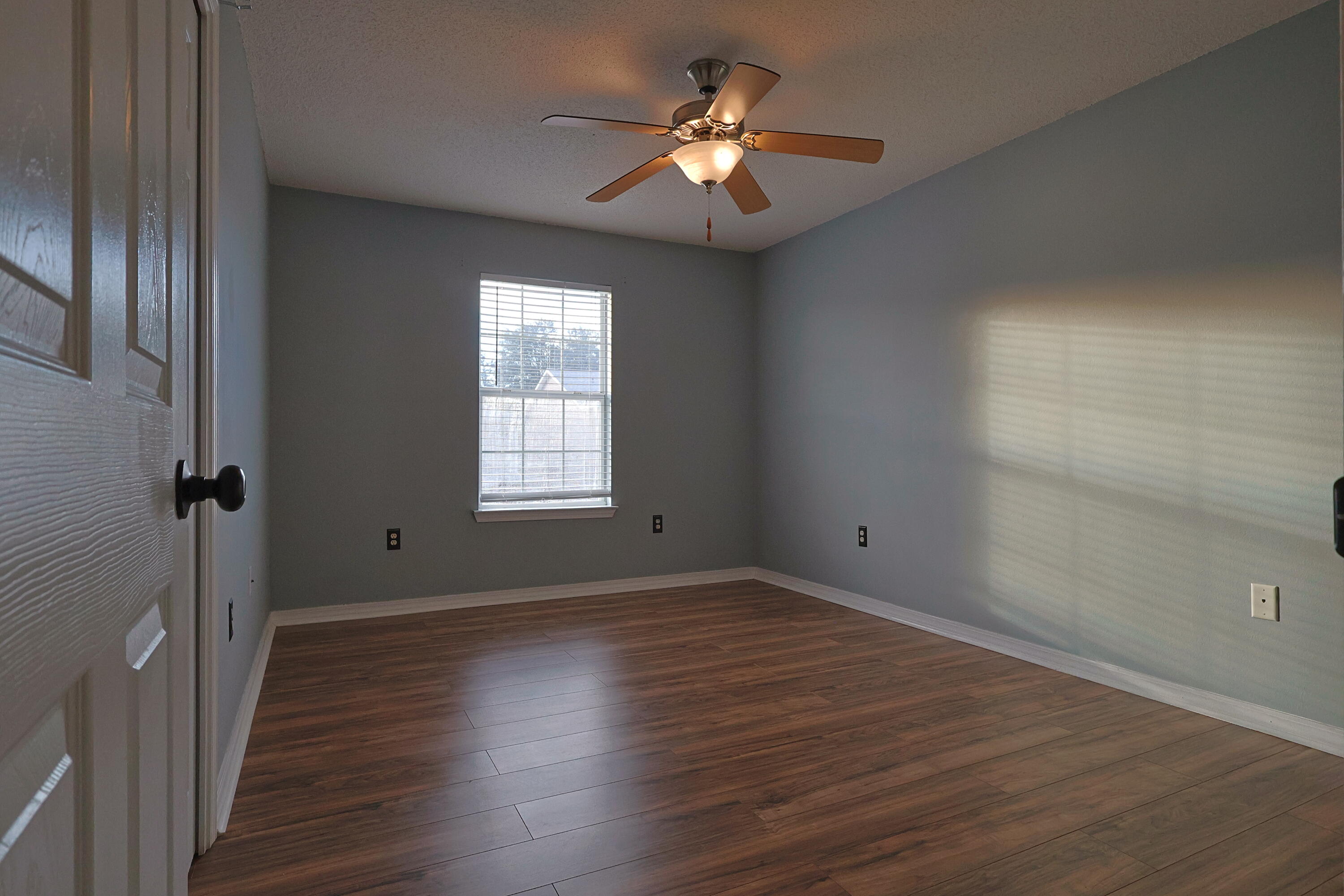 487 Keystone Road Mary Esther, FL 32569 - Photo 16 of 35 a view of a livingroom with a fan a hardwood floor and a ceiling fan