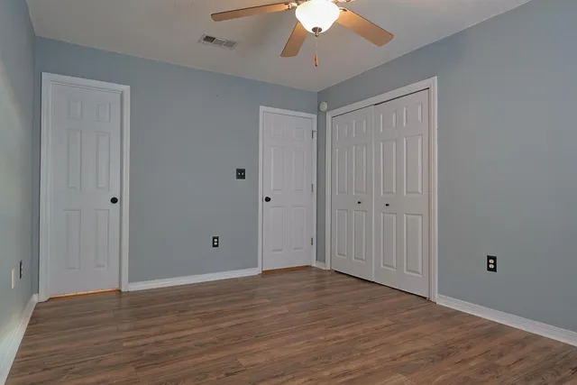 a view of an empty room with wooden floor