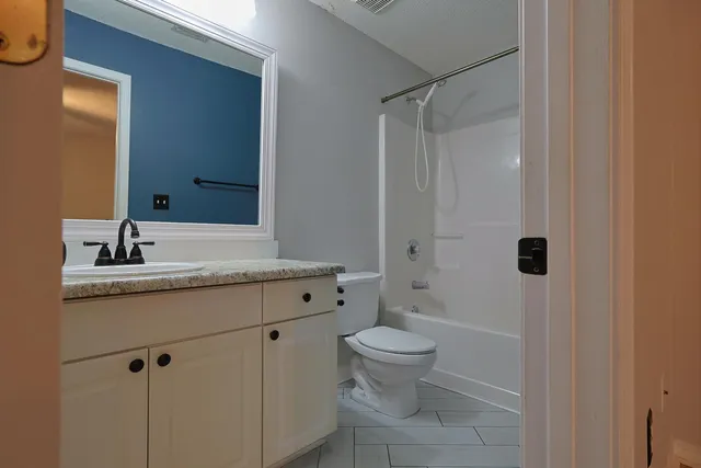 a bathroom with a granite countertop sink toilet and shower