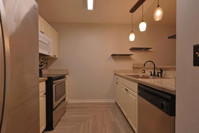 a kitchen with sink stove and cabinets