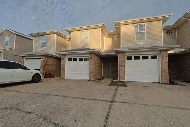 a front view of a house with a yard and a garage