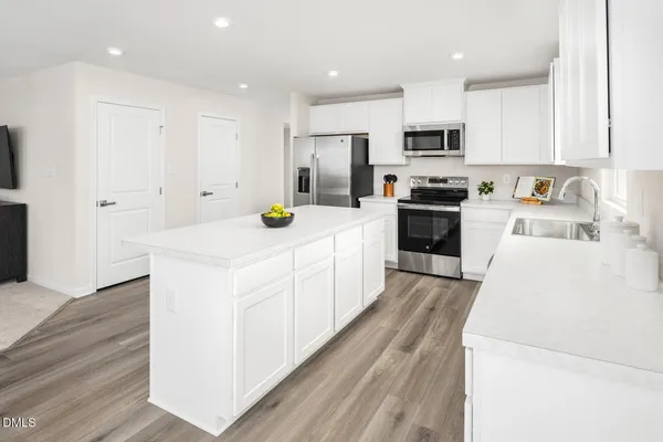a kitchen with a dining table chairs and wooden floor