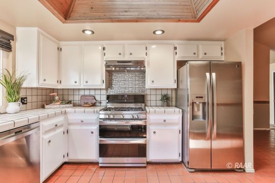 429 Debra Lane Ridgecrest, CA 93555 - Photo 3 of 34 a kitchen with a refrigerator sink and white cabinets