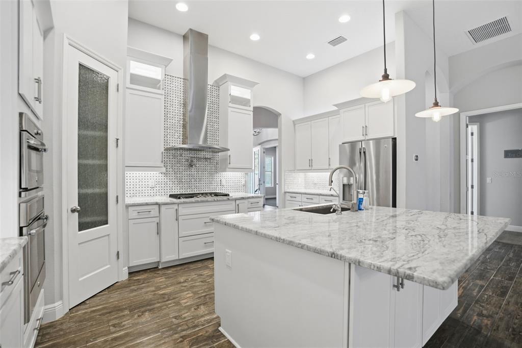 31999 Watoga Loop Wesley Chapel, FL 33543 - Photo 13 of 67 a kitchen with stainless steel appliances granite countertop a stove a sink and a refrigerator