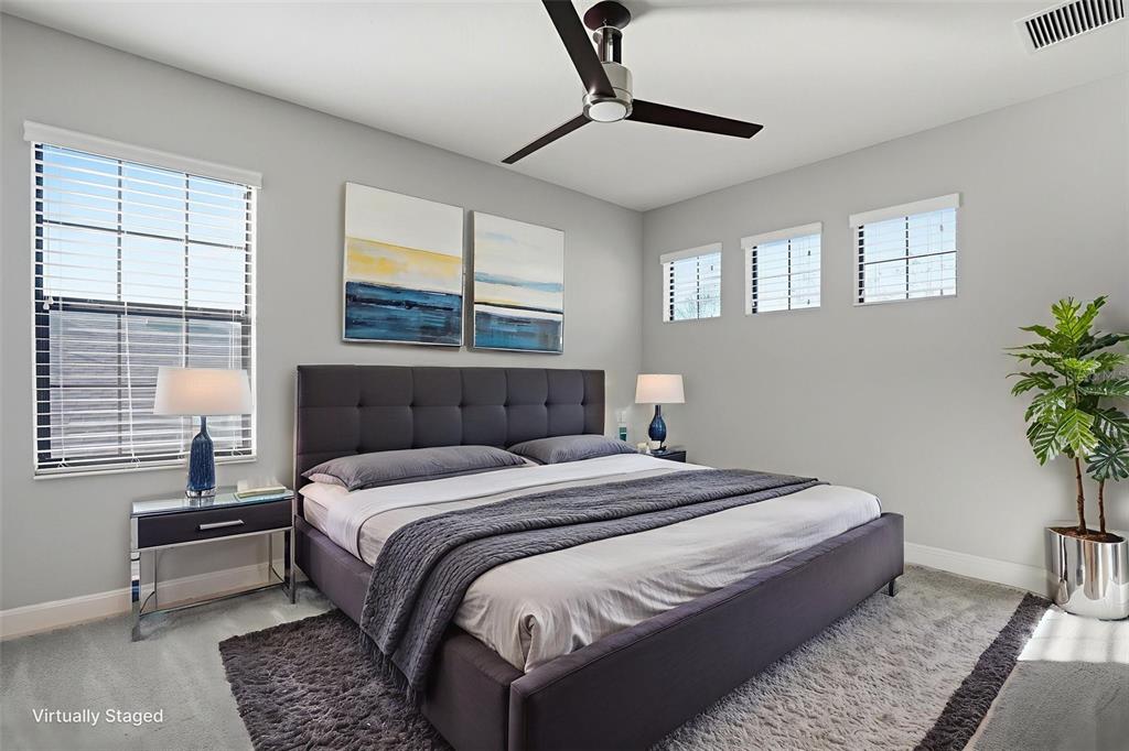 31999 Watoga Loop Wesley Chapel, FL 33543 - Photo 48 of 67 a bedroom with a large bed and a potted plant