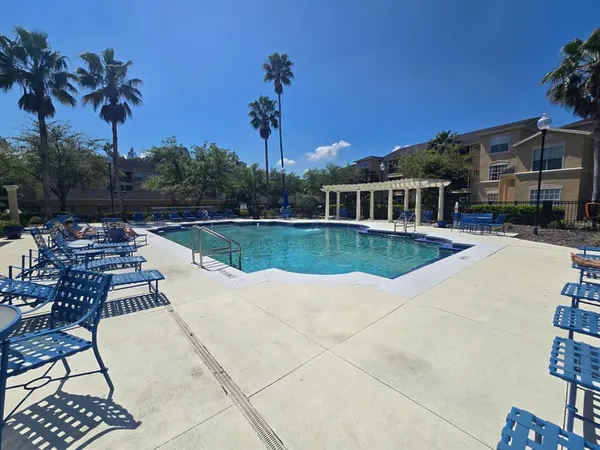 a view of a house with pool and sitting area