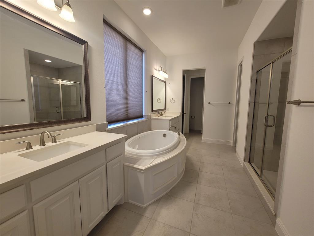 8553 Gerbera Daisy Road Frisco, TX 75035 - Photo 16 of 32 Bathroom featuring two vanities, a bath, light tile patterned flooring, and a shower stall