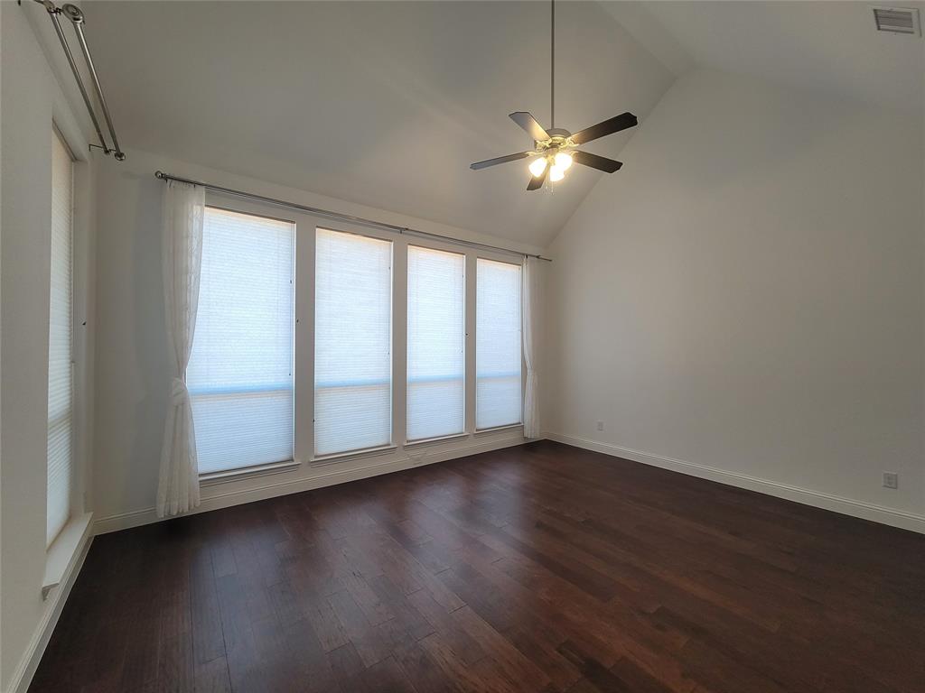 8553 Gerbera Daisy Road Frisco, TX 75035 - Photo 17 of 32 Empty room with dark wood-style floors, ceiling fan, and high vaulted ceiling