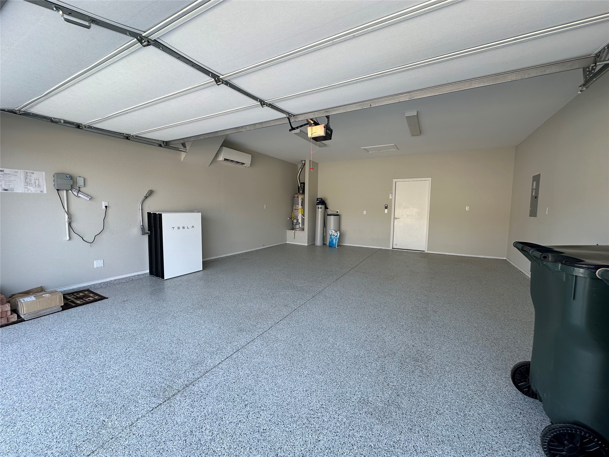 219 Coachsmith Street Georgetown, TX 78633 - Photo 21 of 25 Garage featuring a wall mounted AC, refrigerator, baseboards, and gas water heater