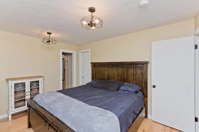 a bedroom with a bed and a chandelier