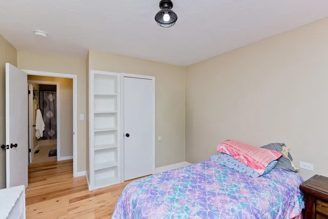 a bedroom with a bed and wooden floor
