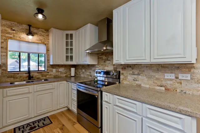a kitchen with stainless steel appliances granite countertop a sink stove and cabinets