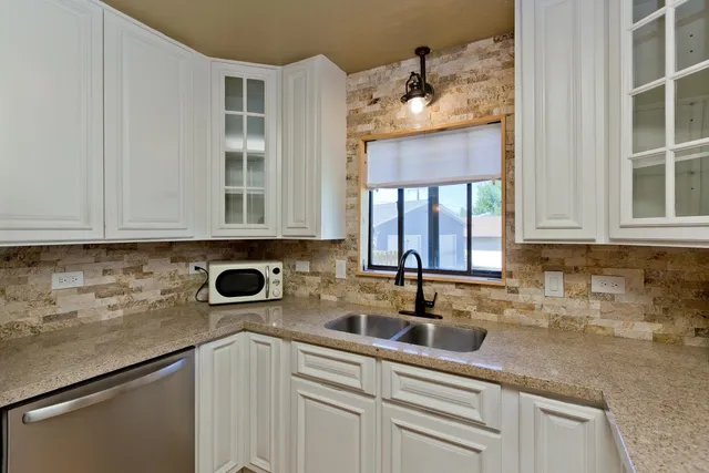 a kitchen with stainless steel appliances white cabinets and a sink