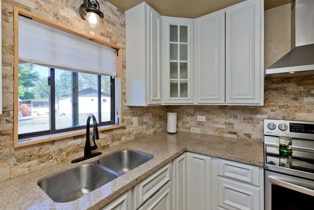 a kitchen with stainless steel appliances a sink a stove and cabinets
