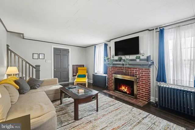 a living room with furniture a flat screen tv and a fireplace