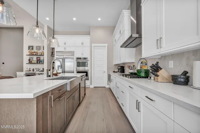 a kitchen with stainless steel appliances granite countertop a sink a stove and cabinets
