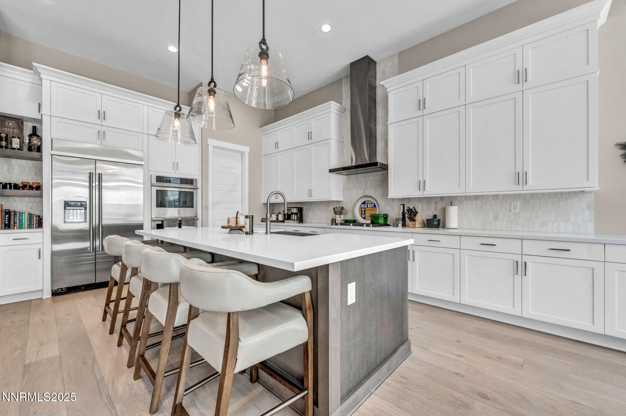 5441 Side Saddle Trail Reno, NV 89511 - Photo 7 of 25 a kitchen with stainless steel appliances kitchen island granite countertop a wooden floor and white cabinets