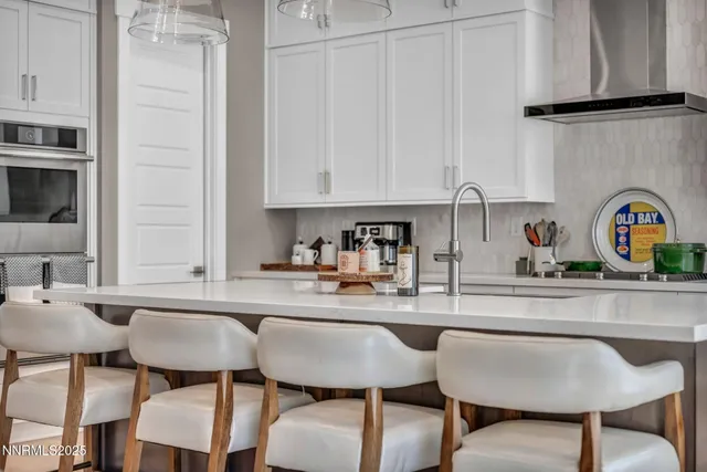 a kitchen with stainless steel appliances a table and chairs in it
