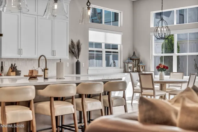 a dining room with furniture and large windows
