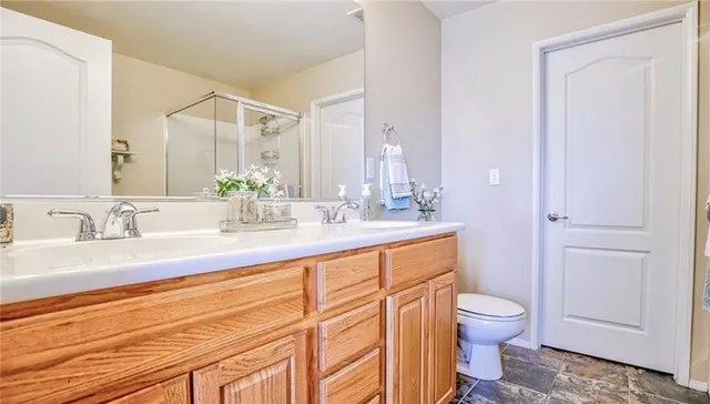 a bathroom with a granite countertop sink mirror vanity and toilet