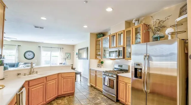 a large kitchen with stainless steel appliances granite countertop a refrigerator and a sink