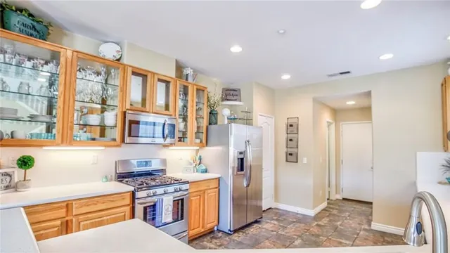 a kitchen with stainless steel appliances granite countertop a refrigerator and a stove top oven