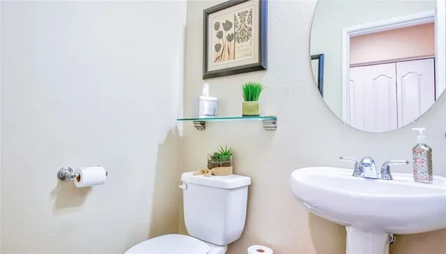 a bathroom with a toilet a sink and mirror