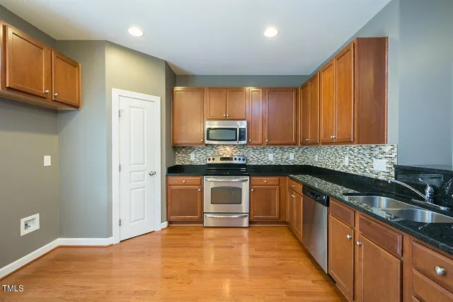 a kitchen with granite countertop wooden cabinets and a stove top oven