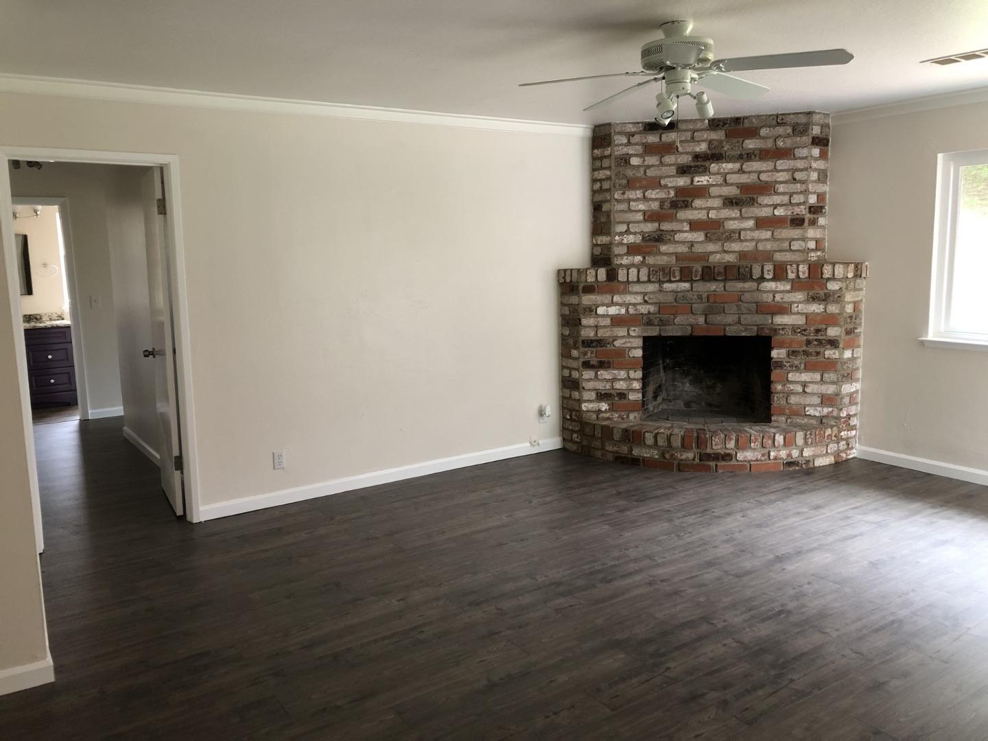 13375 Taft Circle Salinas, CA 93906 - Photo 3 of 18 an empty room with wooden floor fireplace and windows