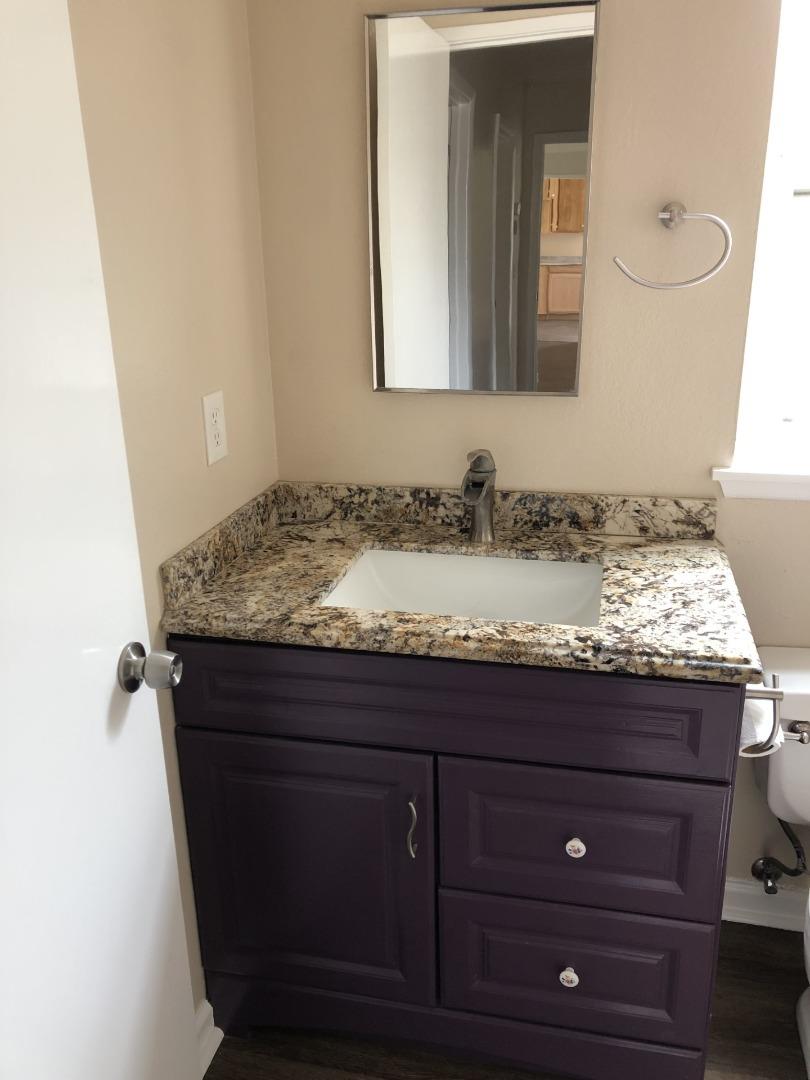 13375 Taft Circle Salinas, CA 93906 - Photo 7 of 18 a bathroom with a granite countertop sink and a mirror