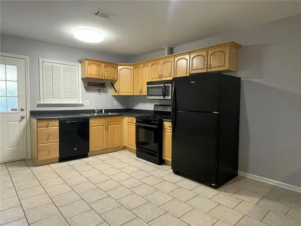 a kitchen with stainless steel appliances granite countertop a refrigerator and a sink
