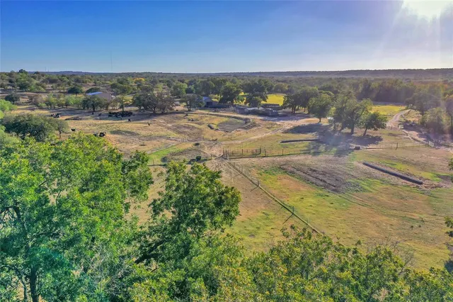 an aerial view of residential houses with outdoor space and trees