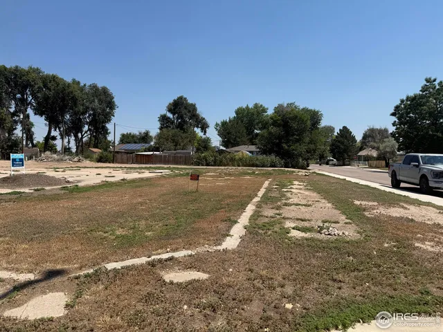 a view of a dirt road with a building in the background