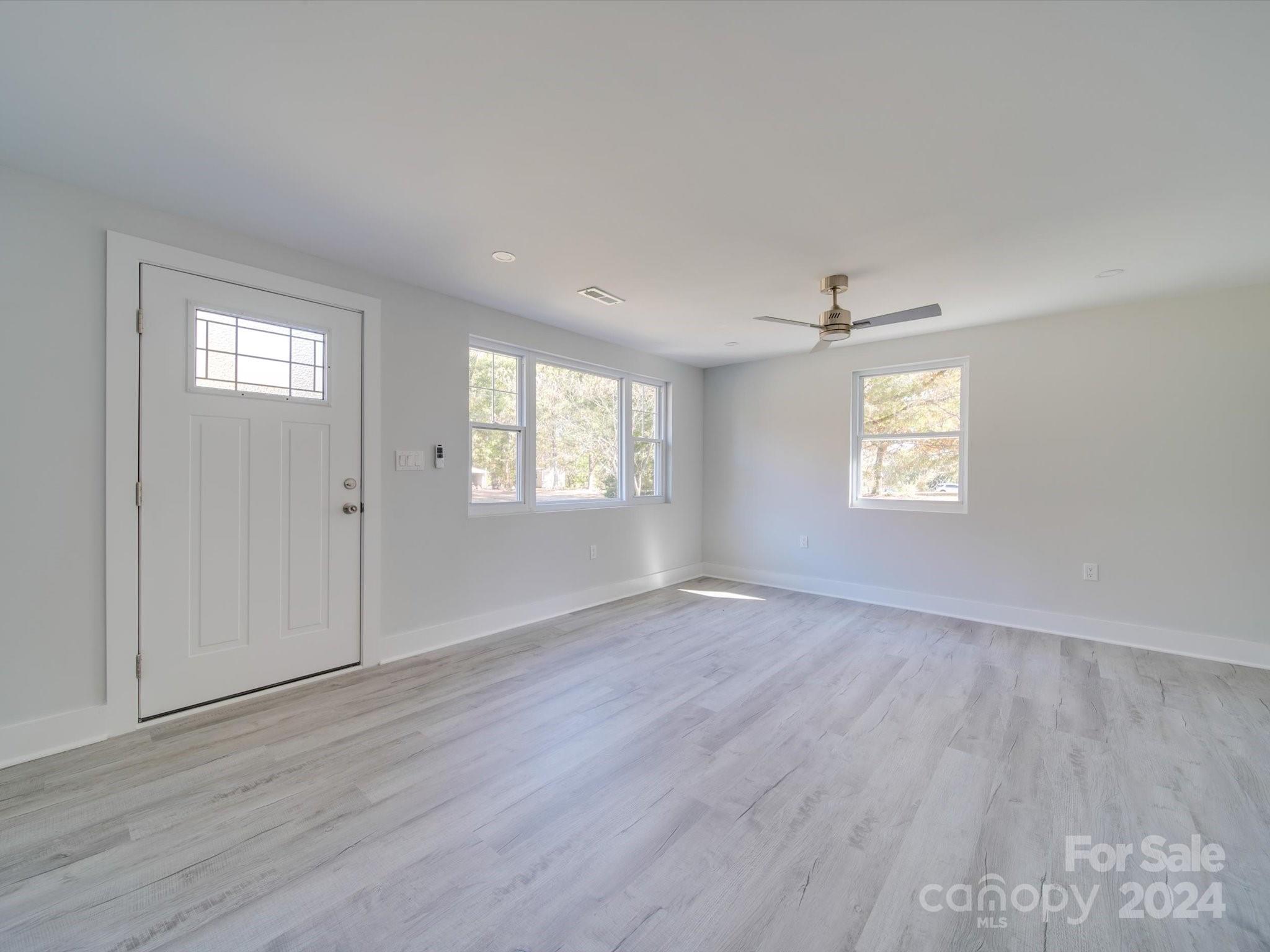 11522 Crestview Lane Locust, NC 28097 - Photo 14 of 40 an empty room with wooden floor and windows