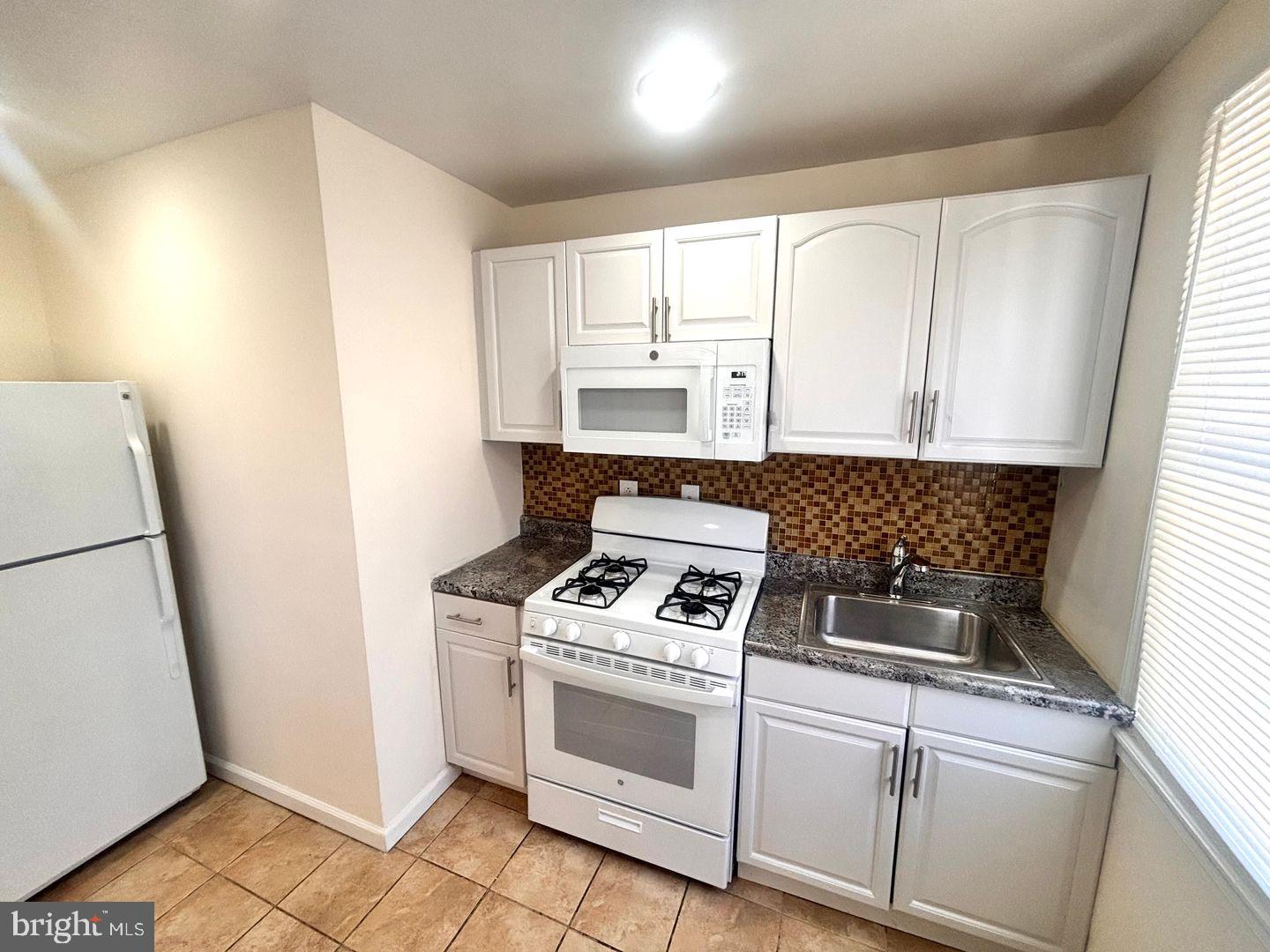 1622 Murdoch Road Philadelphia, PA 19150 - Photo 5 of 12 a white stove top oven sitting inside of a kitchen