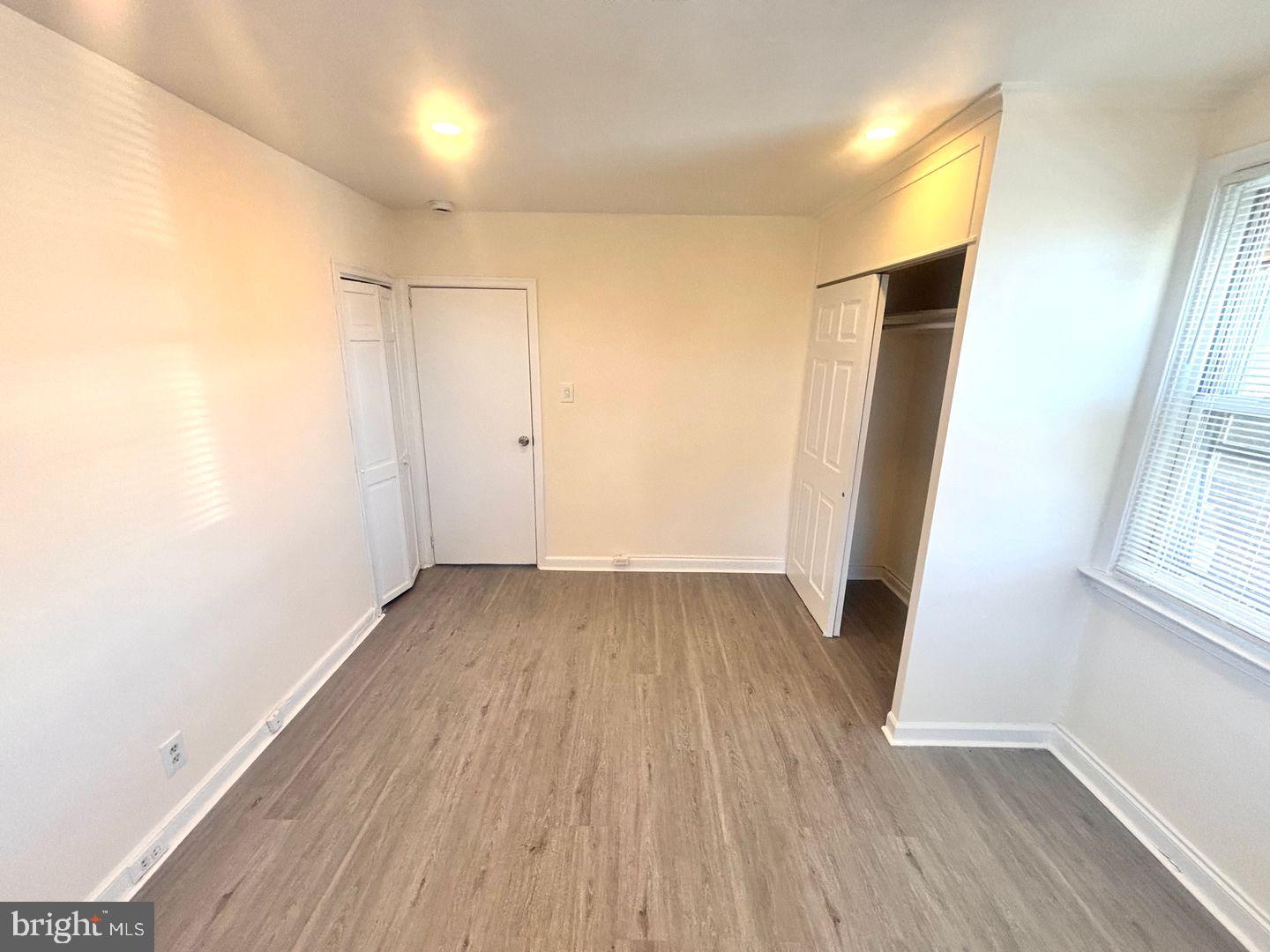 1622 Murdoch Road Philadelphia, PA 19150 - Photo 9 of 12 an empty room with wooden floor and windows