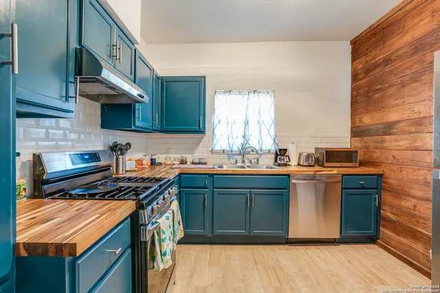 a kitchen with stainless steel appliances granite countertop a stove a sink and a microwave