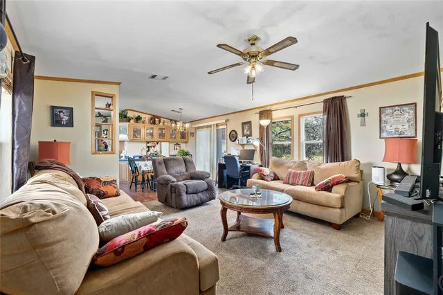 a large kitchen with stainless steel appliances granite countertop a stove a sink dishwasher and white cabinets with wooden floor