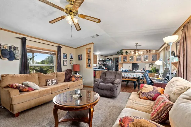 a view of a dining room with furniture a kitchen and chandelier